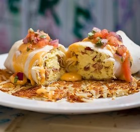 Breakfast burrito stuffed w/ bacon, sausage, scrambled eggs & onions served w/ hash browns & queso, & salsa fresca