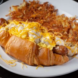 Toasted croissant stuffed with sausage links, scrambled eggs, topped with white gravy and a side of hashbrowns