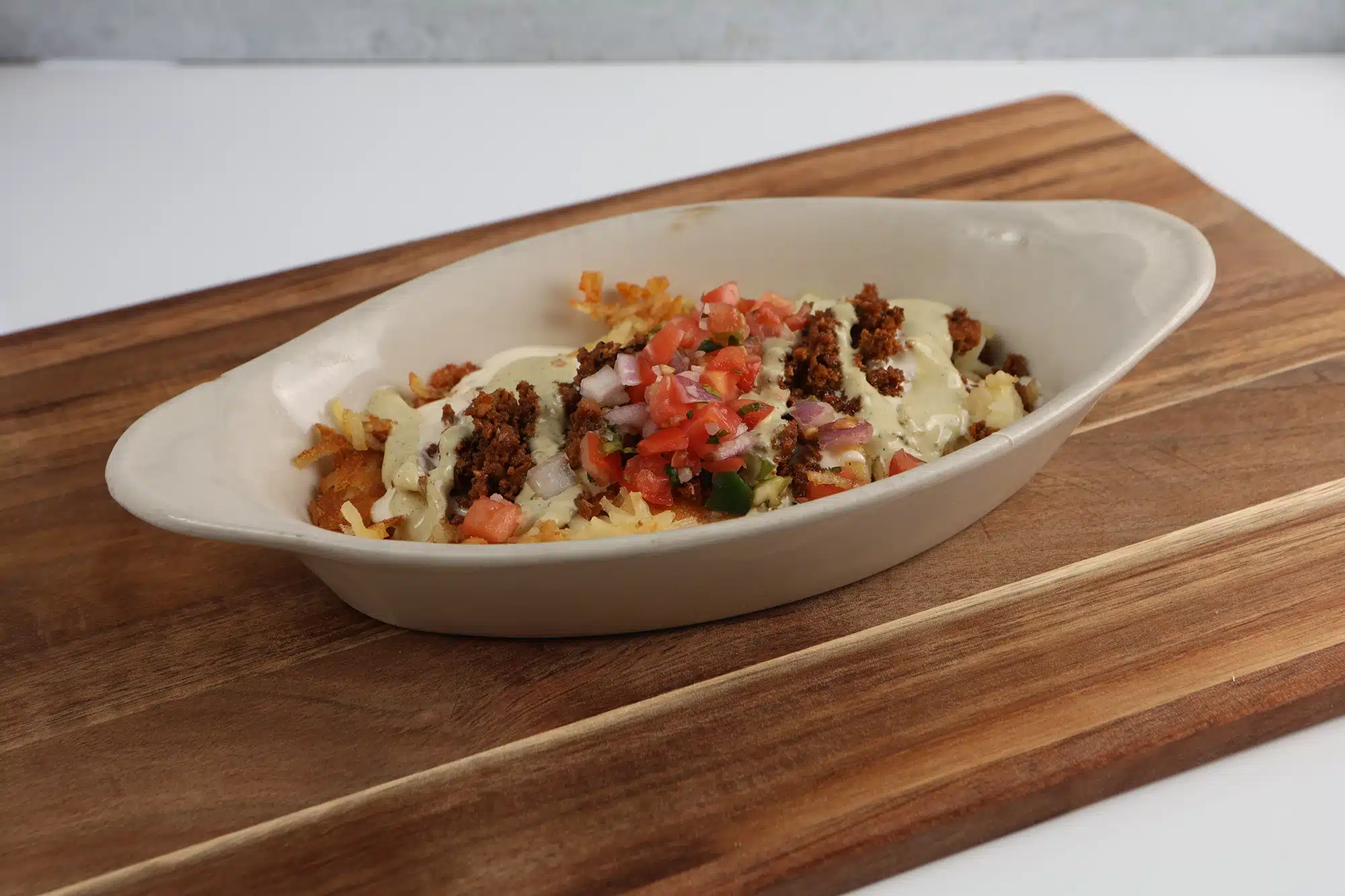 Hash browns topped with seasoned ground chorizo, creamy ranch drizzle, and pico de gallo.