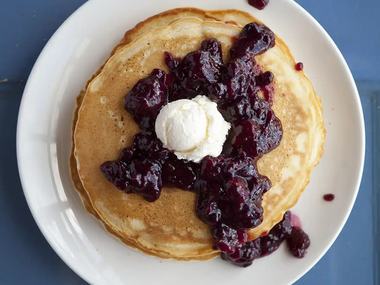 Pancakes under blueberry compote.