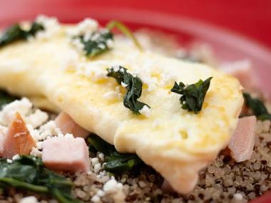A loaded omelet on a red plate.