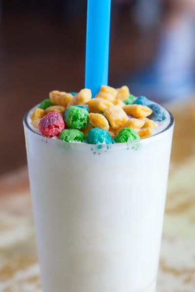 A cereal-topped milkshake with a bright blue straw.