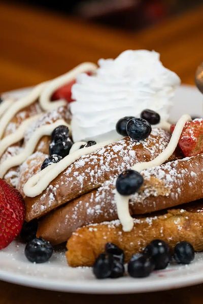French toast with strawberries, blueberries and powdered sugar.