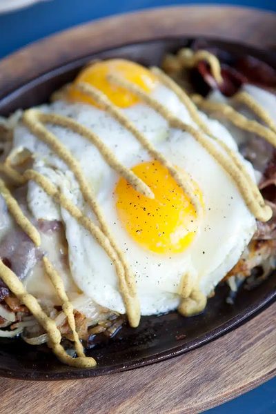 A cast-iron skillet breakfast topped with a fried egg.